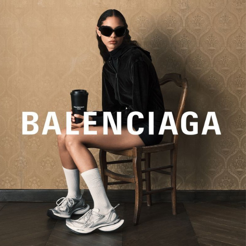 Balenciaga Kampagnenbild – Model mit Balenciaga Sneakern, schwarzem Hoodie und Designer Accessoire