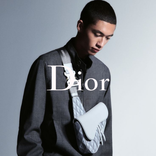 Dior Kollektion – Mann vor grauem Hintergrund mit Pullover und Shoulderbag von Dior, eleganter Lifestyle bei Closory