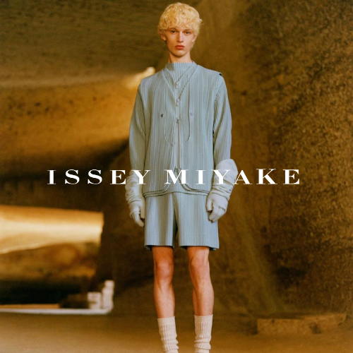 Issey Miyake Kollektion – Model in Höhle mit blauem Sweatshirt und blauer Shorts, avantgardistischer Lifestyle bei Closory