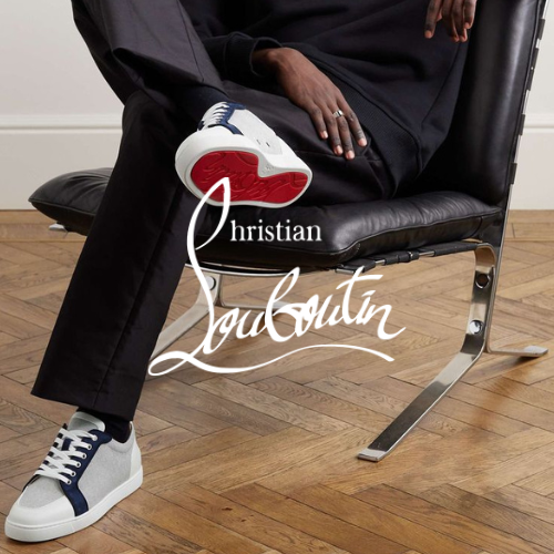 Christian Louboutin Kollektion – Model sitzend auf Stuhl mit Sneakern mit roter Sohle in weißem Raum mit Parkettboden, eleganter Lifestyle bei Closory