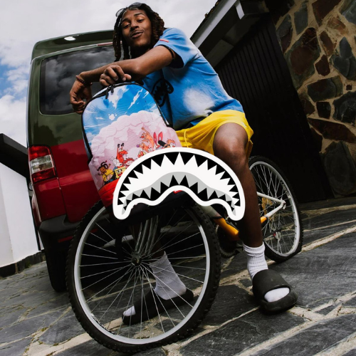 Playground Kollektion – Mann auf Fahrrad lehnend mit plattem Reifen, Rucksack in den Händen, lockeres Outfit, urbaner Streetstyle bei Closory