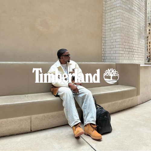 Timberland Kollektion – Mann in Stiefeln sitzt auf Betonbank im urbanen Hintergrund, trägt Fleecejacke und Jeans, lässiger Outdoor-Lifestyle bei Closory