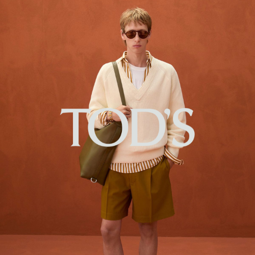 Tod’s Kollektion – Model luxuriös gekleidet in orangefarbenem Raum, eleganter Lifestyle bei Closory